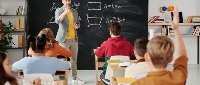 Teacher explaining geometry as students engage in a modern classroom setting.